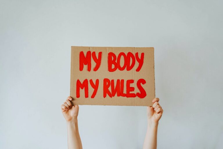 Hände halten Schild hoch mit Text "My Body My Rules"